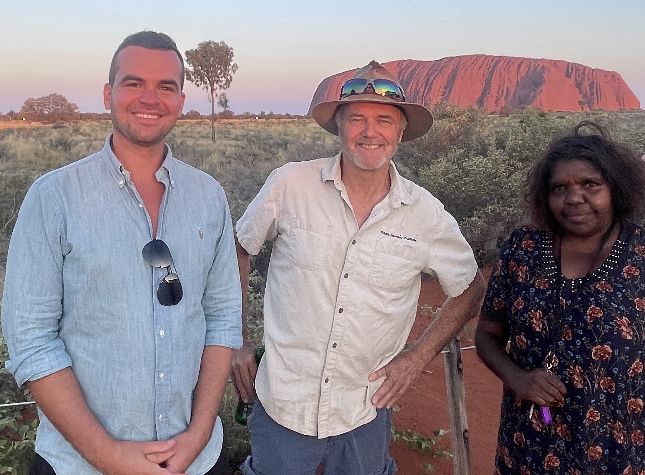 The Red Spaces team with a local Anangu guide at Uluru at sunset